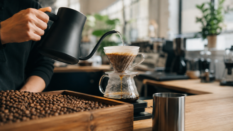 Geröstete Specialty-Coffee-Bohnen neben einer Tasse Filterkaffee [Bildinhalt mit KI erstellt]